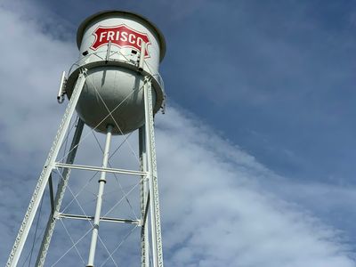 The Frisco, TX water tower against a blue sky.