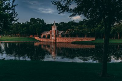Chapel tower reflected in a pond at dusk in Las Colinas, Irving, TX.