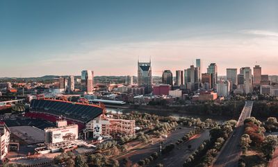Downtown Nashville, TN skyline with Nissan Stadium along the Cumberland River.